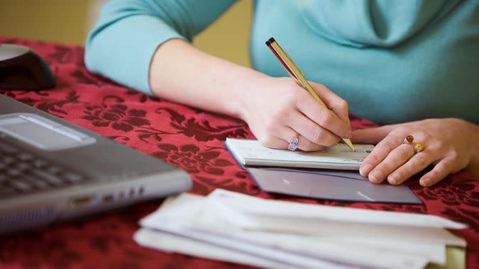 woman writing a check in her checkbook