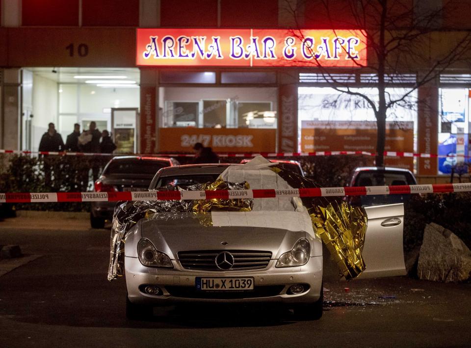 A car with dead bodies stands in front of a bar in Hanau, Germany, Thursday, Feb. 20, 2020. German police say several people were shot to death in the city of Hanau on Wednesday evening. (AP Photo/Michael Probst)