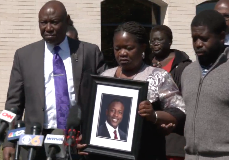 Caroline Ouko, center, holds up a picture of her son Irvo Otieno as she stands with civil rights attorney Ben Crump, left, and Otieno's brother Leon Ochieng, right, during a news conference on March 16, 2023.