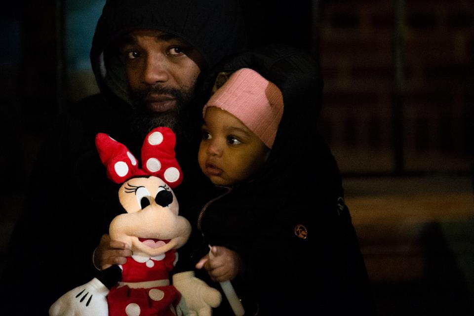 Family members gather by the Bache-Martin School for a vigil Thursday, Jan. 6, 2022 to honor the victims of a rowhouse fire in Philadelphia.