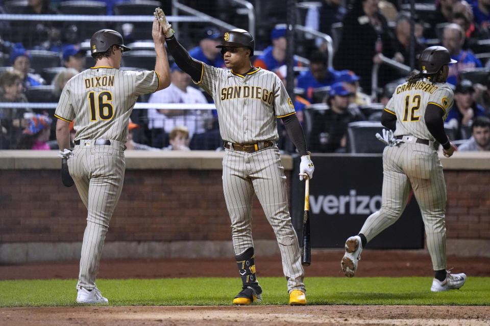 San Diego Padres' Juan Soto, center, celebrates with Brandon Dixon (16) and Luis Campusano (12) after they scored on a double by Manny Machado against the New York Mets during the fifth inning of a baseball game Tuesday, April 11, 2023, in New York. (AP Photo/Frank Franklin II)