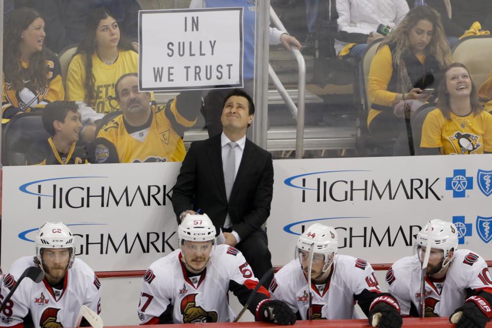 <p>Ottawa Senators head coach Guy Boucher looks up at the scoreboard as a Pittsburgh Penguins fan holds up a sign for Penguins head coach Mike Sullivan during the first period of Game 5 in the NHL hockey Stanley Cup Eastern Conference finals, Sunday, May 21, 2017, in Pittsburgh. (AP Photo/Gene J.Puskar) </p>