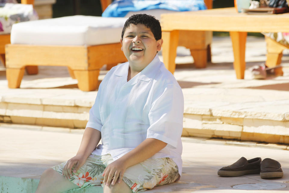 teen sitting by the pool with his feet in