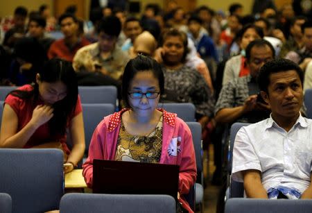 People sit as they wait for tax amnesty at the country's tax headquarters in Jakarta, Indonesia September 30, 2016. REUTERS/Beawiharta