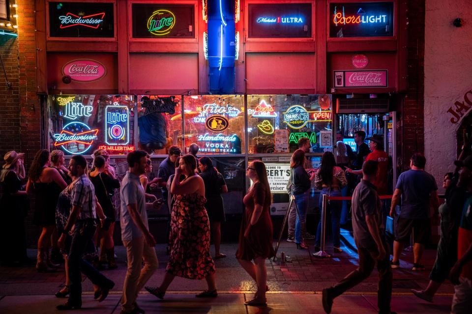 People walk past Robert’s Western World on Lower Broadway in Nashville, Tenn., Friday, July 14, 2023.