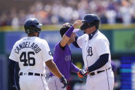 Detroit Tigers designated hitter Miguel Cabrera is greeted Colorado Rockies shortstop Jose Iglesias after his 3,000th career hit during the first inning of the first baseball game of a doubleheader against the Rockies, Saturday, April 23, 2022, in Detroit. (AP Photo/Carlos Osorio)