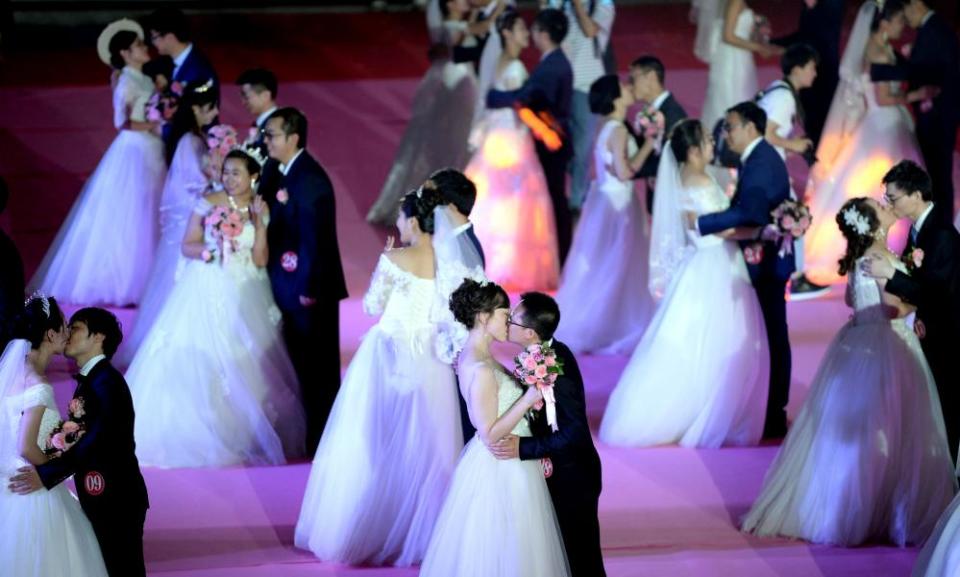 Fifty-six couples participate in a group wedding ceremony