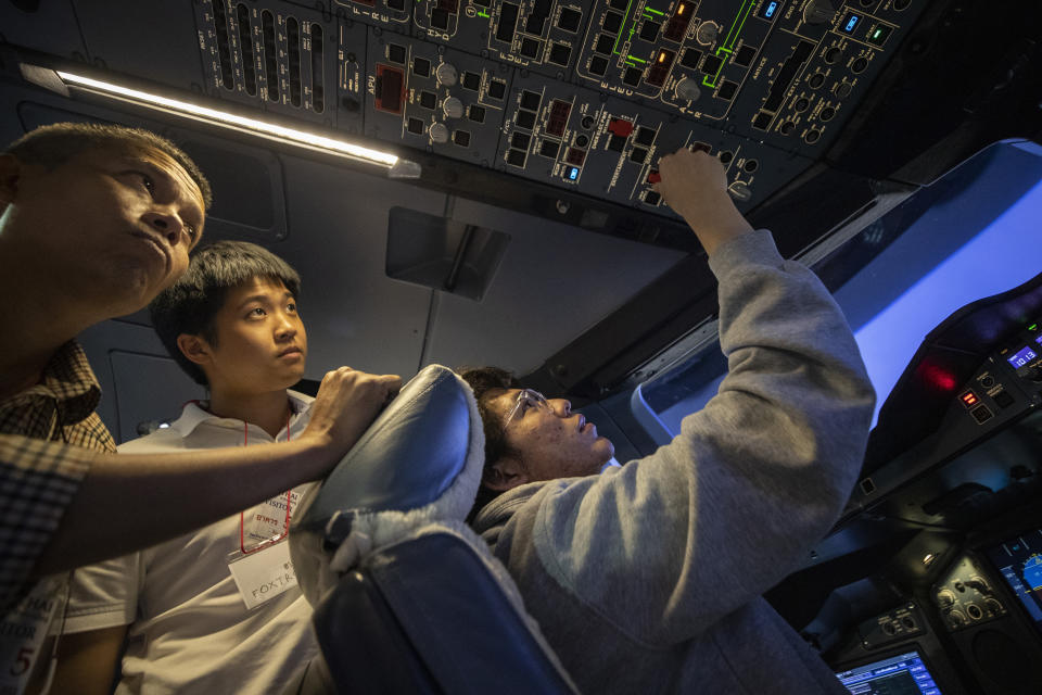 A customer sits in a Boeing A380 flight simulator for a flight experience at the Thai Airways head office in Bangkok, Thailand on Oct. 3, 2020. The airline is selling time on its flight simulators to wannabe pilots while its catering division is serving meals in a flight-themed restaurant complete with airline seats and attentive cabin crew. The airline is trying to boost staff morale, polish its image and bring in a few pennies, even as it juggles preparing to resume international flights while devising a business reorganization plan. (AP Photo/Sakchai Lalit)