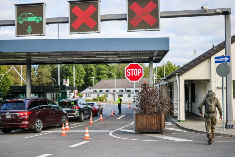 Soldiers check the entrance to the NATO air base, a soldier in camouflage clothing is walking towards the air base. NATO had declared the second-highest warning level at its air base in Geilenkirchen, North Rhine-Westphalia. Christoph Reichwein/dpa