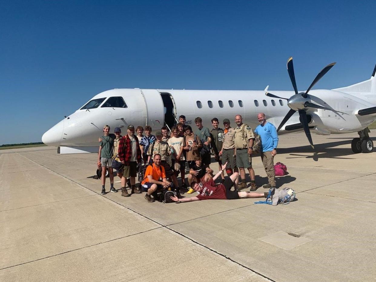 Members of Appleton-based Boy Scout troops 12 and 73 pose in front of a plane in Columbia, Missouri before heading home Tuesday evening after their Amtrak train derailed Monday.