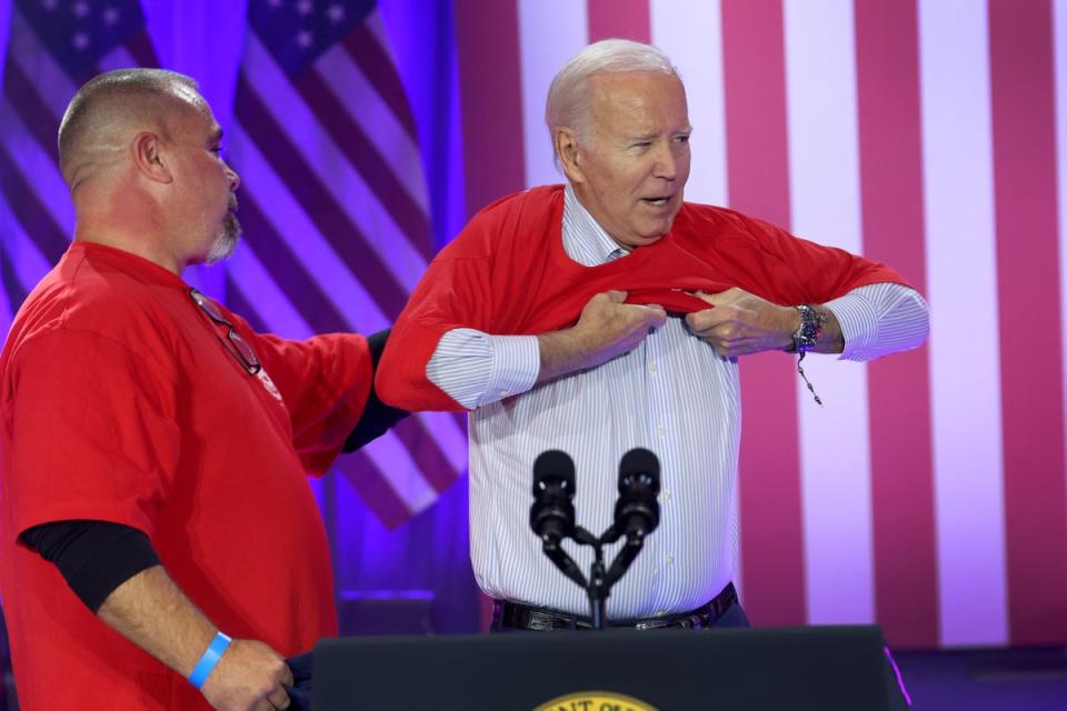 Biden puts on a United Auto Workers shirt before speaking to autoworkers in Belvidere, Illinois (Getty Images)