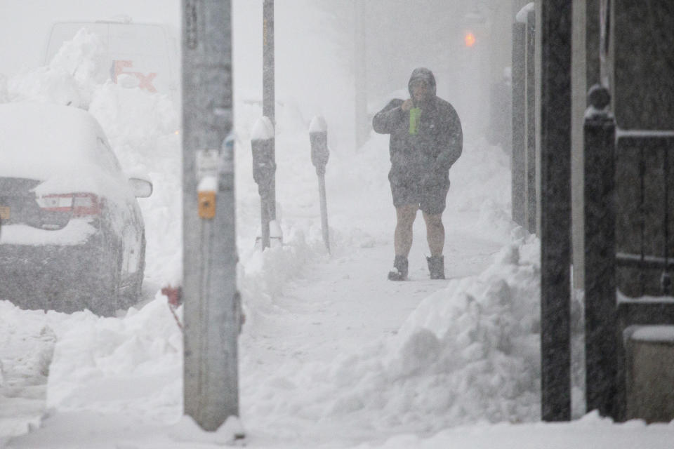 A person walks through downtown in the snow Friday, Nov. 18, 2022, in Buffalo, N.Y.  A dangerous lake-effect snowstorm paralyzed parts of western and northern New York, with nearly 2 feet of snow already on the ground in some places and possibly much more on the way.  (AP Photo/Joshua Bessex)