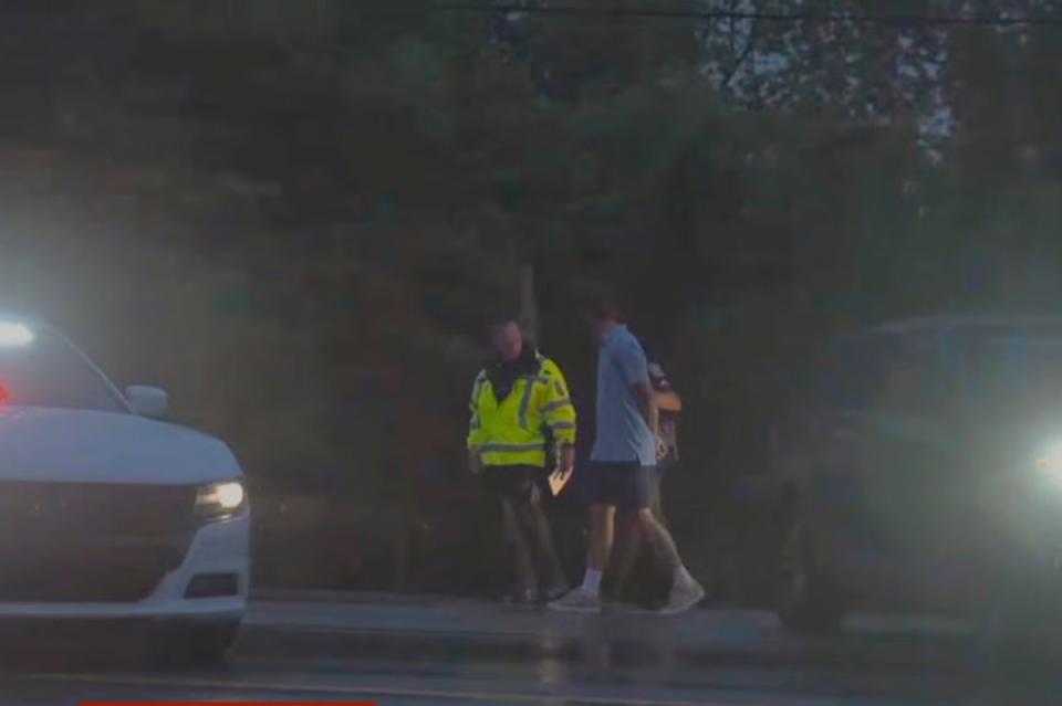 Masters champion Scottie Scheffler is escorted by police after being handcuffed near Valhalla Golf Club, site of the PGA Championship golf tournament, early Friday, May 17, 2024 (ESPN/AP)