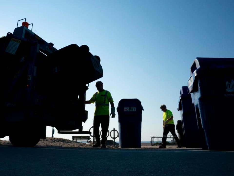 City of Toronto workers pick up garbage in the Beaches area. Unionized city workers continue to handle operations east of Yonge Street and newly-released contract prices show their services are now cost the same as private companies operating in the west end. (Frank Gunn/The Canadian Press - image credit)