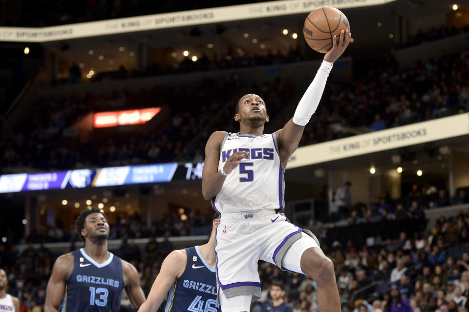 Sacramento Kings guard De'Aaron Fox (5) shoots the ball ahead of Memphis Grizzlies guard John Konchar (46) and forward Jaren Jackson Jr. (13) in the second half of an NBA basketball game, Tuesday, Nov. 22, 2022, in Memphis, Tenn. (AP Photo/Brandon Dill)