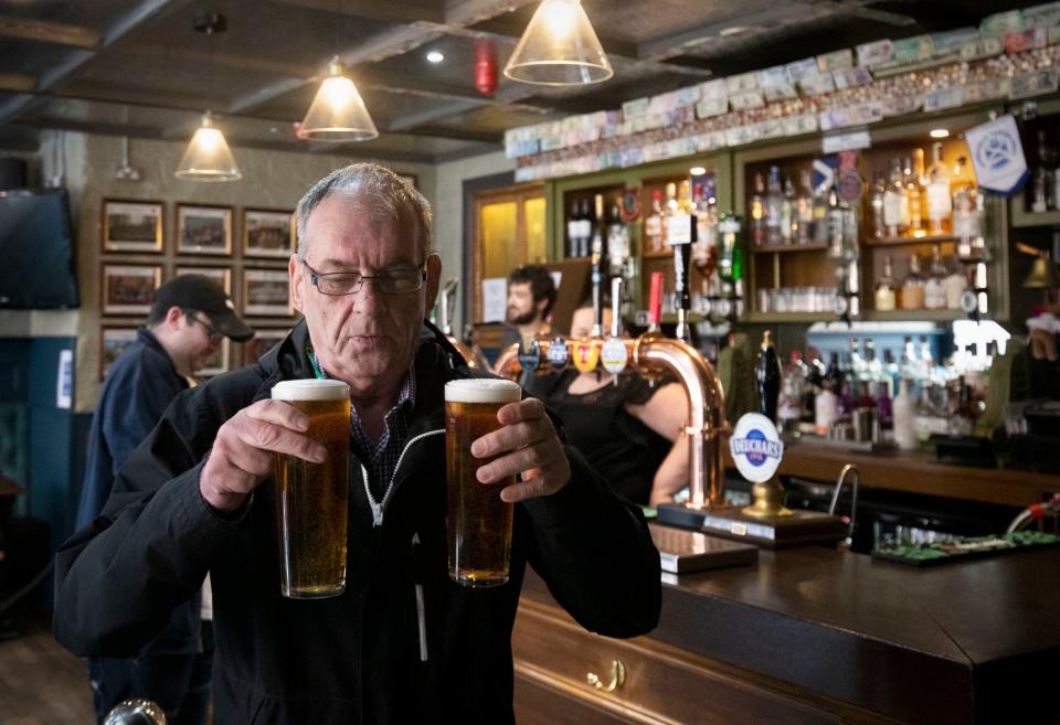 A man carries beers in a pub (PA)