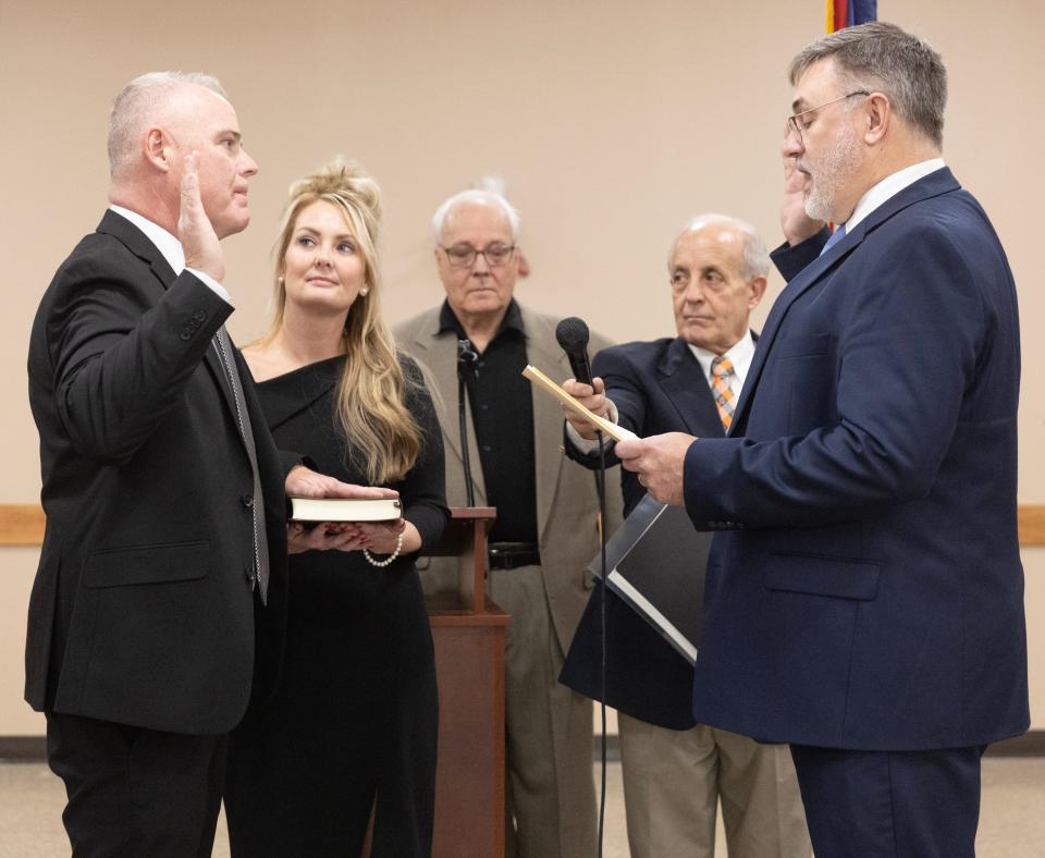 Jamie Slutz (left) is sworn in as Massillon mayor by friend, Keith Warstler (right), and announced by Municipal Judge Edward Elum, as Slutz's wife Christie Slutz holds the Bible. Also pictured is Master of Ceremonies Steve Yablonski (center).