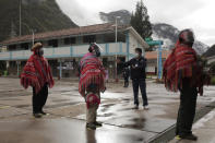 An electoral official instructs voters to keep social distance to prevent the spread of the new coronavirus during general elections in Ollantaytambo, Peru, Sunday, April 11, 2021. (AP Photo/Sharon Castellanos)