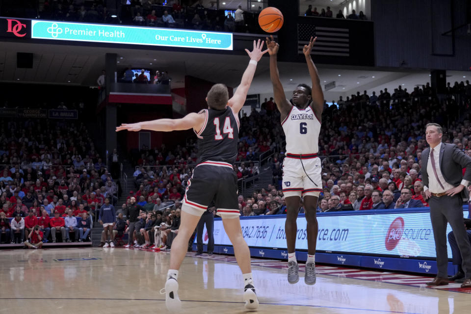 Dayton guard Enoch Cheeks, right, attempts a three-point basket against Davidson guard Angelo Brizzi during the first half of an NCAA college basketball game, Tuesday, Feb. 27, 2024, in Dayton, Ohio. (AP Photo/Aaron Doster)