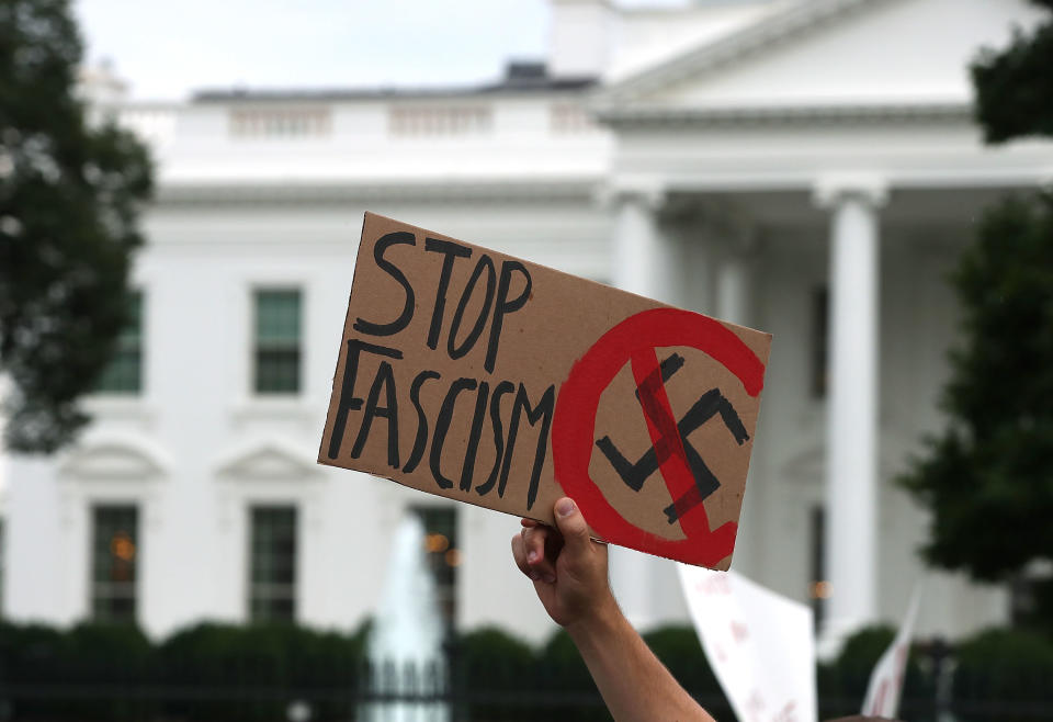 &nbsp;A man holds up a sign during a protest against racism gathered in front of the White House, on August 14, 2017 in Washington, DC.