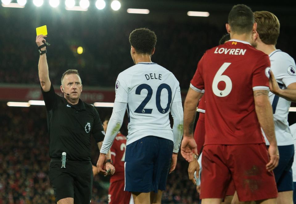 Tottenham Hotspur’s Dele Alli receives a yellow card for diving from referee Jon Moss against Liverpool