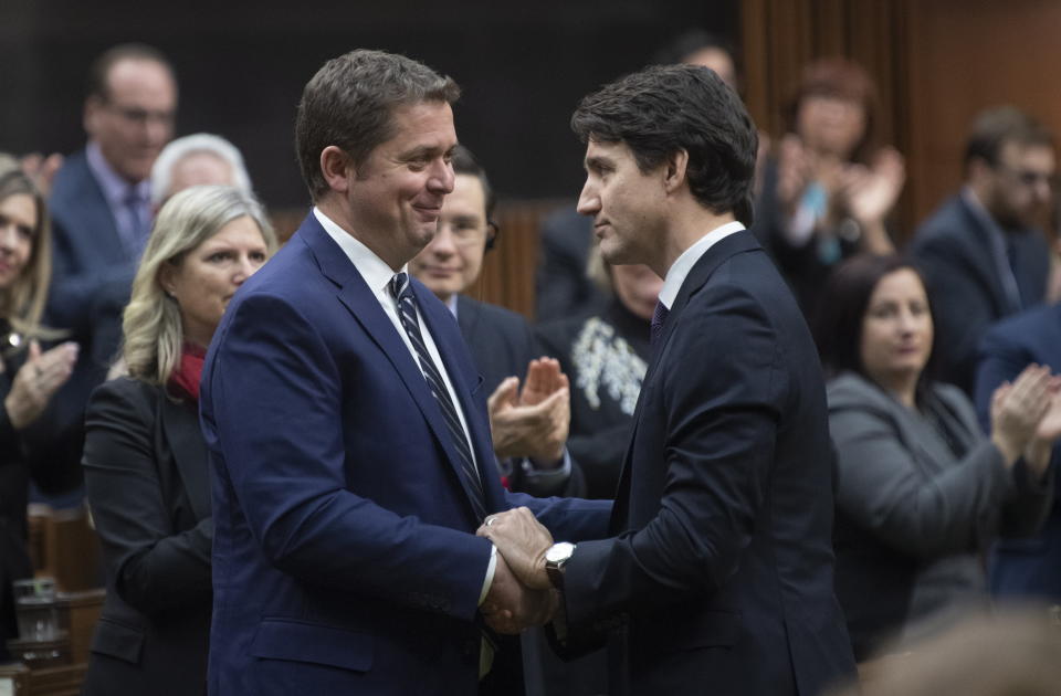 Prime Minister Justin Trudeau, right, shakes hands with Leader of the Opposition Andrew Scheer after he announced he will step down as leader of the Conservatives, Thursday, Dec. 12, 2019, in the House of Commons in Ottawa. (Adrian Wyld/The Canadian Press via AP)