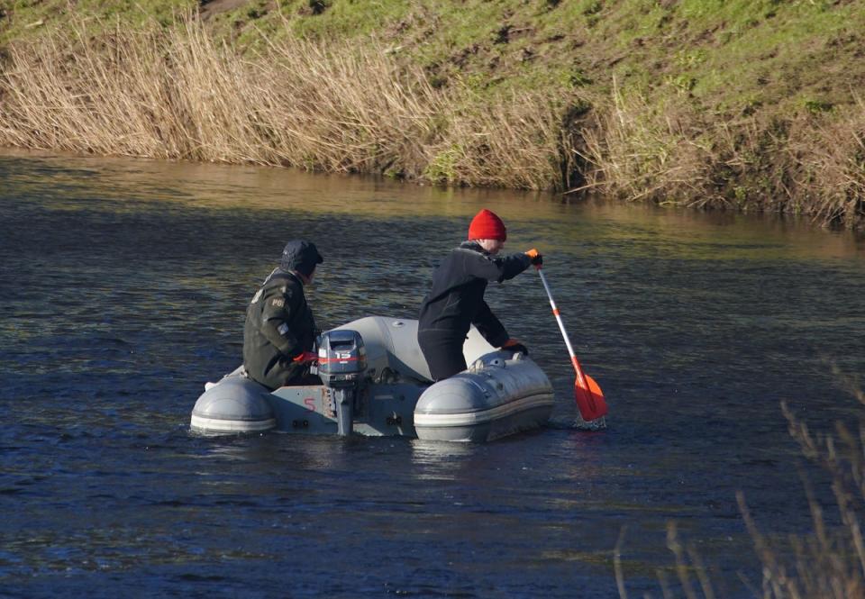 Specialist search officers drive a boat along the River Wyre (PA)