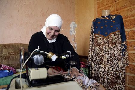 Fawziyeh, a 52-year-old Syrian woman, sews clothes at her house in a small town south of Beirut, Lebanon April 15, 2015. REUTERS/Aziz Taher