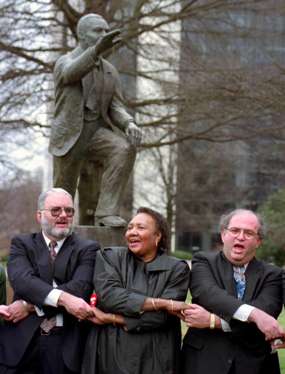 The Rev. Joseph McCutchen, left, Sarah Stevenson, center, and Rabbi Murray Ezring sing ``We Shall Overcome’’ during a service for Dr. Martin Luther King Jr. on Sunday Jan. 15, 1995 at Charlotte’s Marshall Park. CHRISTOPHER A. RECORD