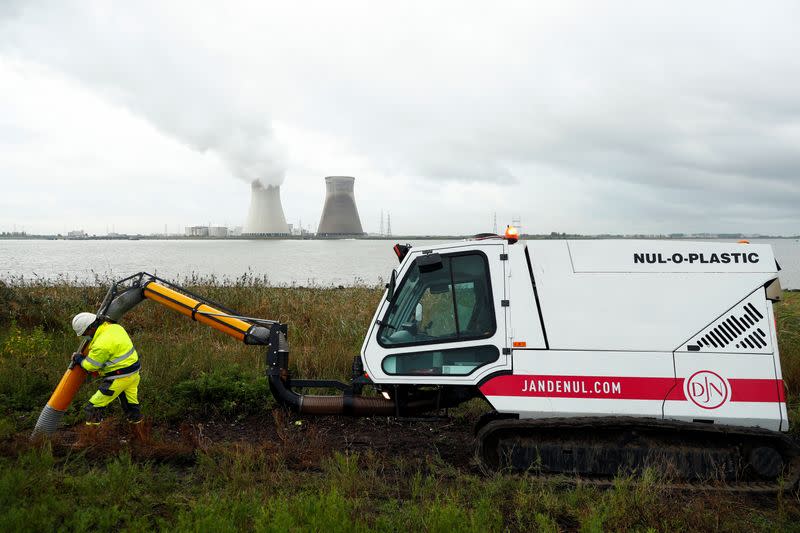 Un trabajador del puerto de Amberes utiliza una "aspiradora" para retirar la basura plástica de la reserva natural de Galgeschoor, cerca de la planta nuclear de Doel, en Amberes, Bélgica