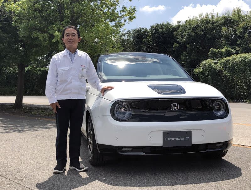 Senior Chief Engineer Tomofumi Ichinose poses for a photograph next to a Honda E electric car in Haga Town