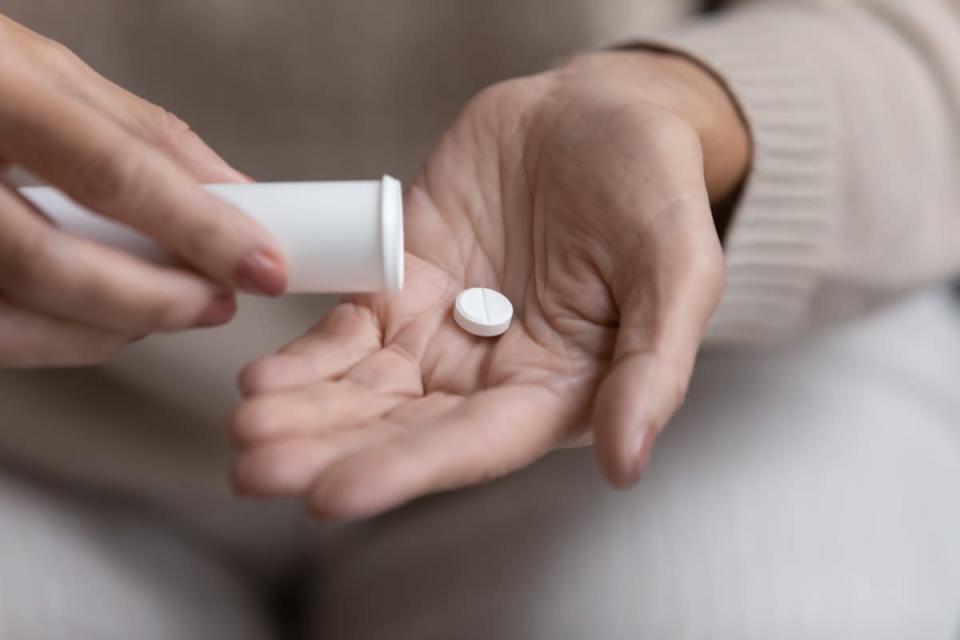 older woman taking pill or supplement