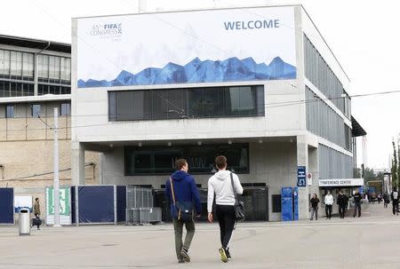 People walk in front of the Hallenstadion, where the upcoming 65th FIFA Congress will take place in Zurich, Switzerland, May 27, 2015. FIFA will elect its new president on May 29, 2015. REUTERS/Arnd Wiegmann