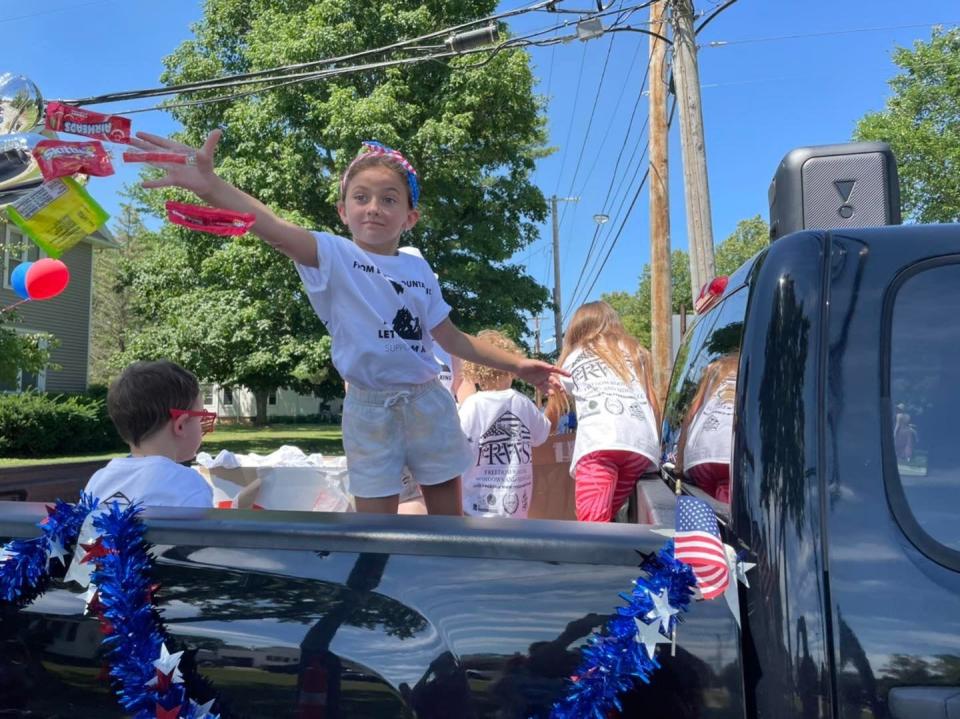 Hazel Donnell throws candy at the 2022 4th of July Grand Parade.