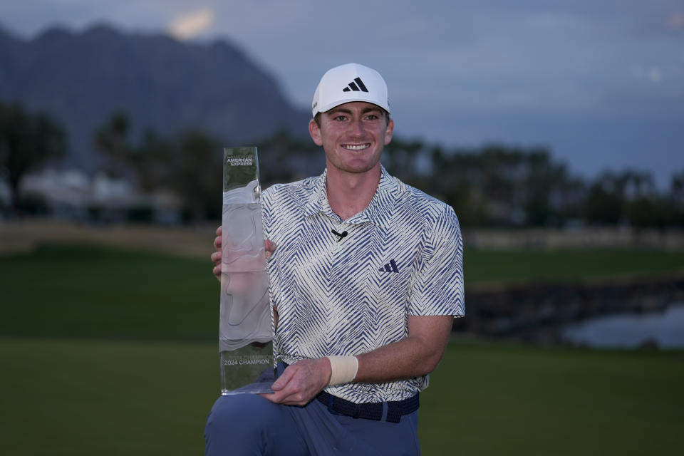 Nick Dunlap holds the trophy after winning the American Express golf tournament, Sunday, Jan. 21, 2024, in La Quinta, Calif. (AP Photo/Ryan Sun)