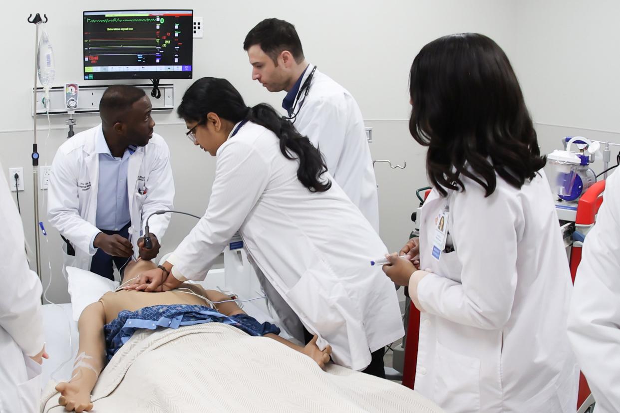 HCA Florida Sarasota Doctors Hospital medical residents Drs. Fru Che,  Nameer Ascandar, Amatul Khan, Nancy Osadiaye-Ebomoyi and Tesnim Hamdan practice on a simulation man at the new resident training lab, which opened Oct. 5.