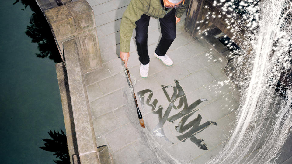 A man making a calligraphy drawing of the Chinese character for “dragon.”