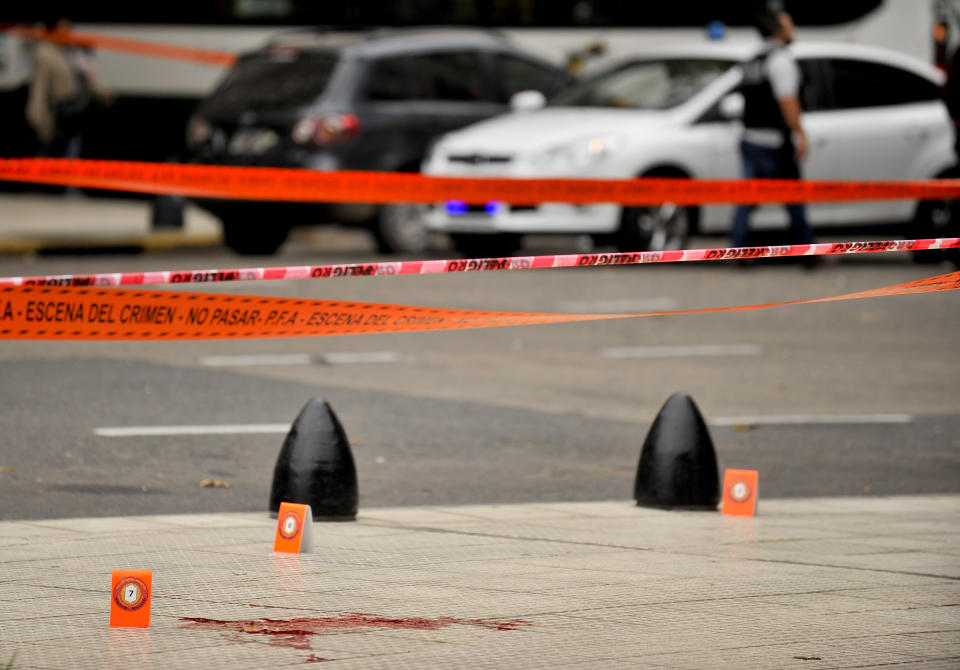 Evidence tent markers dot the crime scene where lawmaker Hector Olivares was seriously injured and another man was killed after they were shot at from a parked car near Congress in Buenos Aires, Argentina, Thursday, May 9, 2019. The lawmaker was seriously injured while provincial official Miguel Marcelo Yadón was killed, in one of the most brazen political attacks in the South American country since it returned to democracy in 1983. (AP Photo/Natacha Pisarenko)