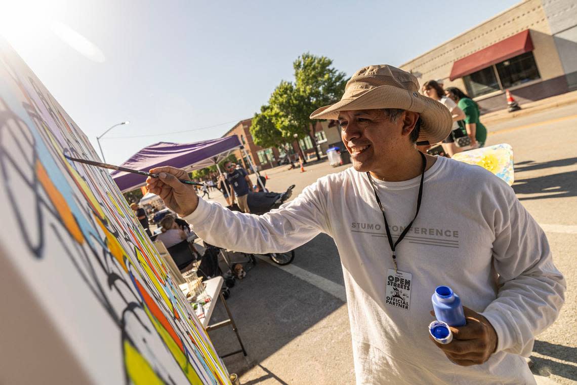 An Artist paints an art piece at Open Streets. Chris Torres/ctorres@star-telegram.com