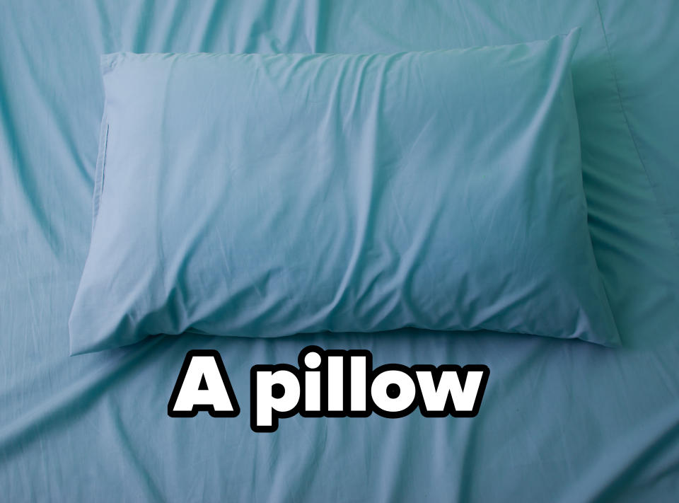 A neatly made bed with a pillow positioned centrally on the bedspread