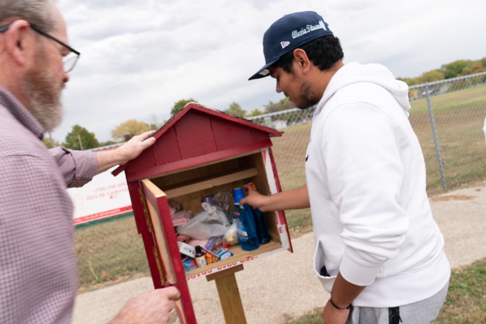 Henry Guerra, right, a senior at Highland Park and member of the Scots Movement Club, shows what is inside a Blessing Box as Topeka Center for Advanced Learning and Careers woodshop teacher Mark Richards looks on.