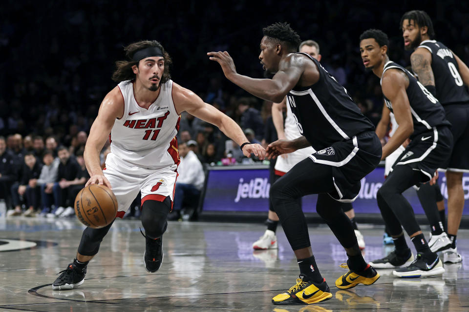 Miami Heat guard Jaime Jaquez Jr. drives to the basket past Brooklyn Nets forward Dorian Finney-Smith during the first half of an NBA basketball game, Saturday, Nov. 25, 2023, in New York. (AP Photo/Adam Hunger)