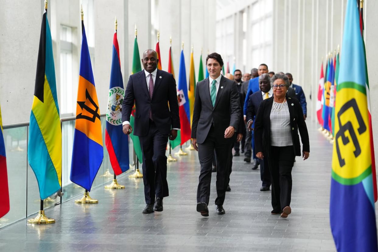 Dominica Prime Minister Roosevelt Skerrit, left to right, Prime Minister Justin Trudeau and CARICOM Secretary General Carla Barnett arrive at the family photo at the Canada-CARICOM summit in Ottawa on Wednesday, Oct.18, 2023.  (THE CANADIAN PRESS/Sean Kilpatrick - image credit)