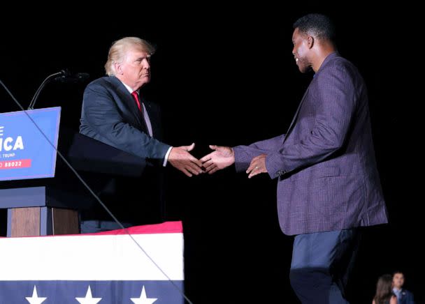 PHOTO: Former college football star and current senatorial candidate Herschel Walker shakes hands with former President Donald Trump during a rally in Perry, Georgia, September 25, 2021. (Dustin Chambers/Reuters, FILE)