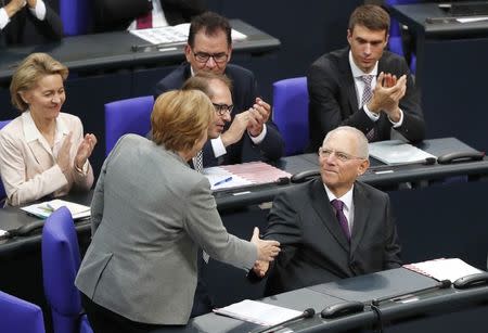 Wolfgang Schaeuble of CDU receives congratulations from German Chancellor Angela Merkel, after he was elected as Bundestagspraesident during the first plenary session of German lower house of Parliament, Bundestag, after a general election in Berlin, Germany, October 24, 2017. REUTERS/Fabrizio Bensch