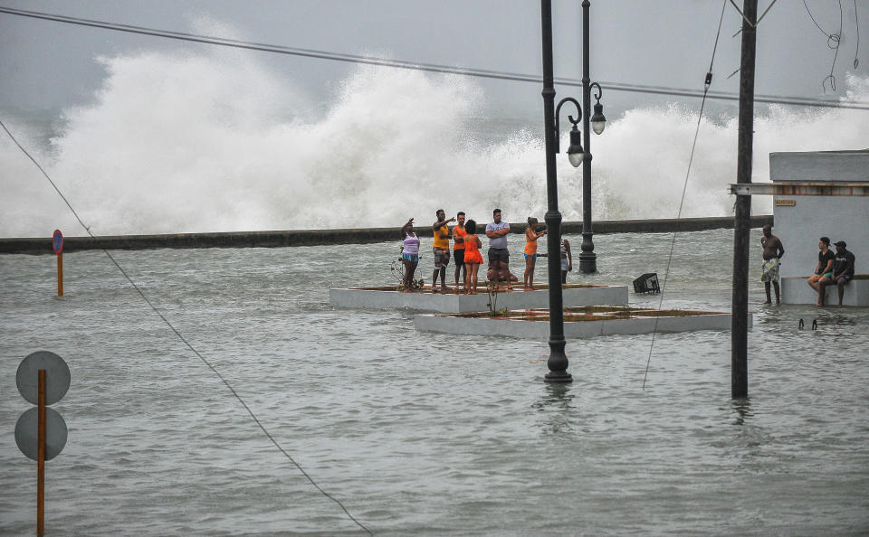 <p>Cuban stay in a flooded street near the Malecon in Havana, on Sept. 10, 2017.<br> (Photo: Yamil Lage/AFP/Getty Images) </p>