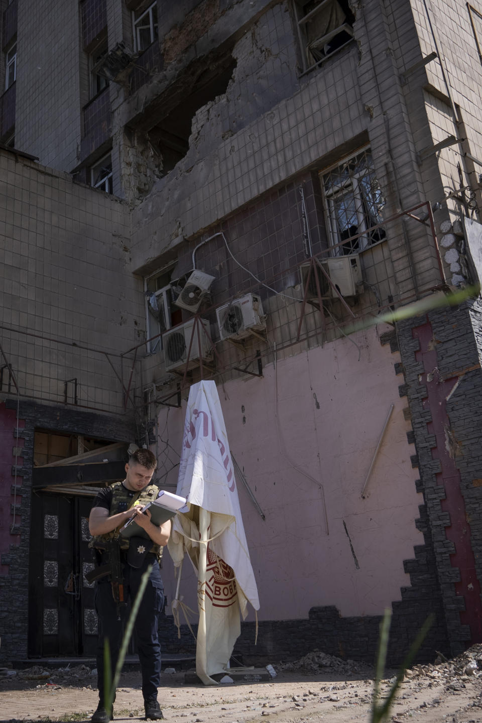 Police inspect an apartment building damaged by a drone during a night attack in Kyiv, Ukraine, Sunday, May 28, 2023. Ukraine's capital was subjected to the largest drone attack since the start of Russia's war, local officials said, as Kyiv prepared to mark the anniversary of its founding on Sunday. (AP Photo/Vasilisa Stepanenko)