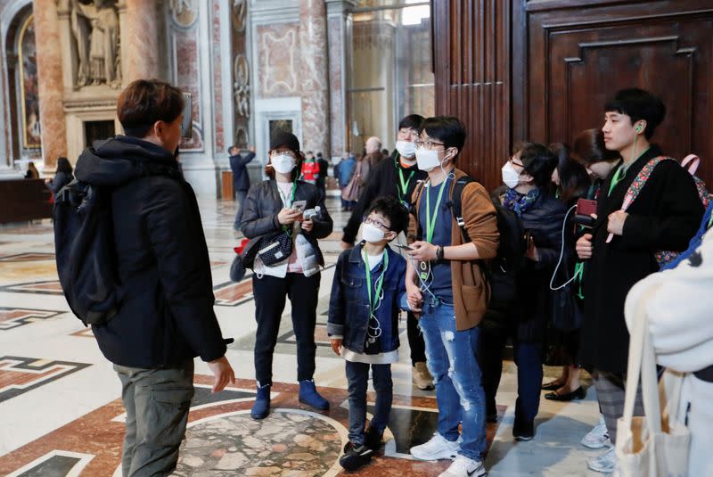 Tourists wearing protective face masks visit the St. Peter's Basilica, after the Vatican reports its first case of coronavirus, at the Vatican