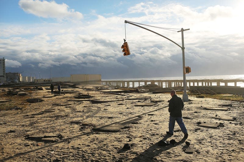 A man walks by the remains of part of the historic Rockaway boardwalk in New York City after large parts of it were washed away during Hurricane Sandy on October 31, 2012.