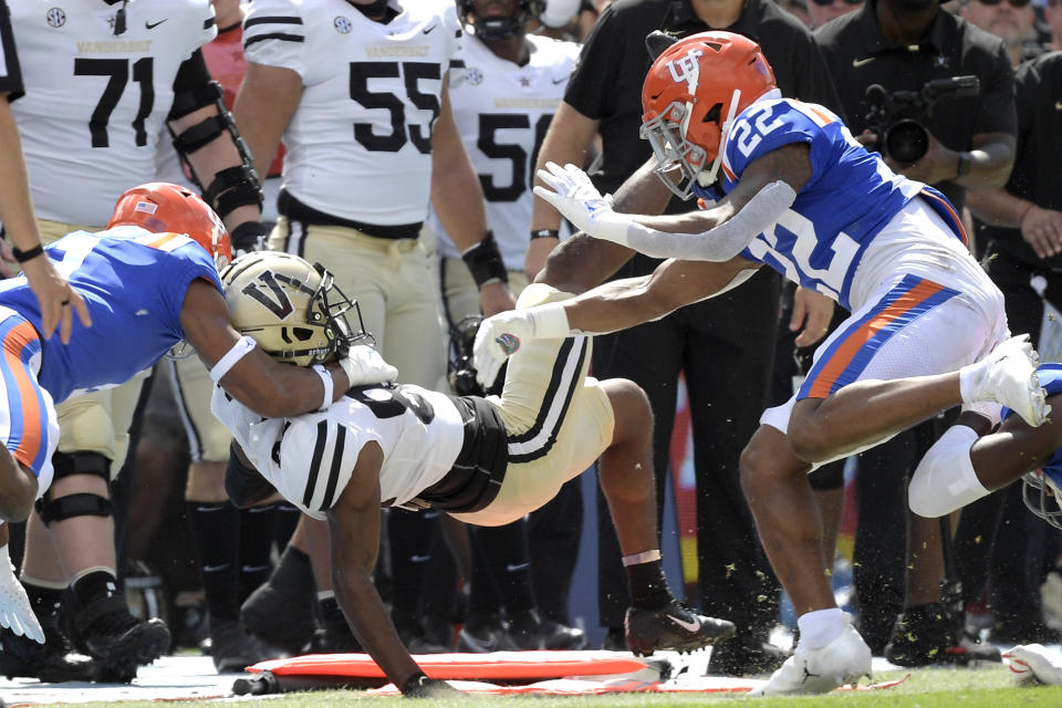 Vanderbilt wide receiver Devin Boddie Jr. (82) is tackled out of bounds by Florida linebacker Mohamoud Diabate, left, and safety Rashad Torrence II (22) on a running play in the first half of an NCAA college football game, Saturday, Oct. 9, 2021, in Gainesville, Fla. Diabate was penalized on the play. (AP Photo/Phelan M. Ebenhack)